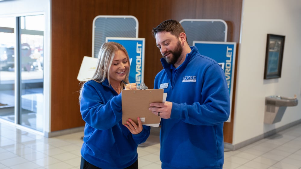 Two Moore Automotive Team members working together in the showroom